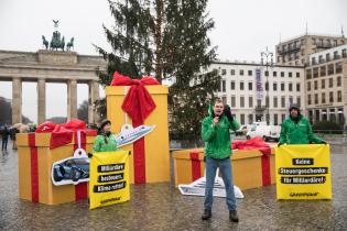 Greenpeace-Aktive protestieren mit Geschenken vor dem Brandenburger Tor für eine Milliardärssteuer