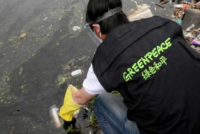 Greenpeace-Aktivist nimmt Wasserprobe in China im Mai 2012