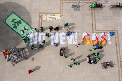 Jugendliche legen einen Schriftzug - no new gas! aus