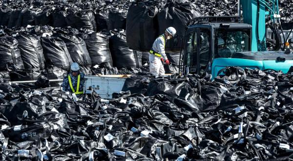 Zwei Arbeiter in einem Meer aus schwarzen Müllsäcken