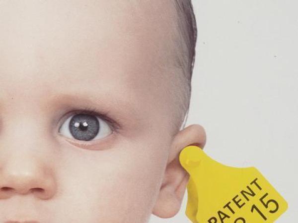 Baby mit Patentclip im Ohr. Symbol für Patente auf Leben.