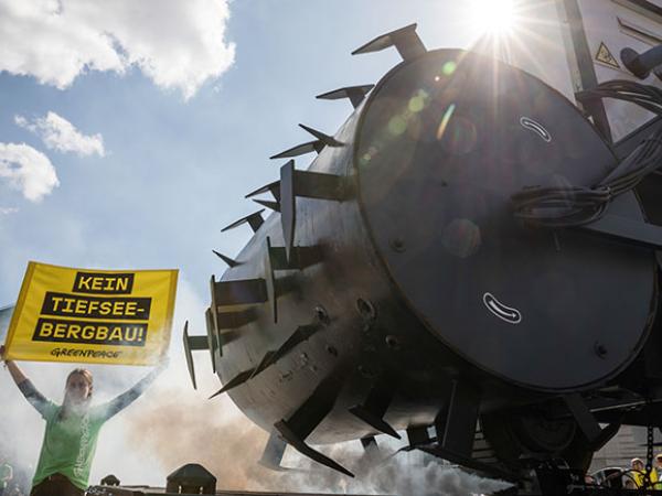 Mit einem fünf Meter hohen und sechs Meter langem Modell eines Tiefseebaggers protestieren Greenpeace-Aktivisten und Aktivistinnen vor dem Brandenburger Tor in Berlin gegen den zerstörerischen Abbau von Rohstoffen im Meeresboden.